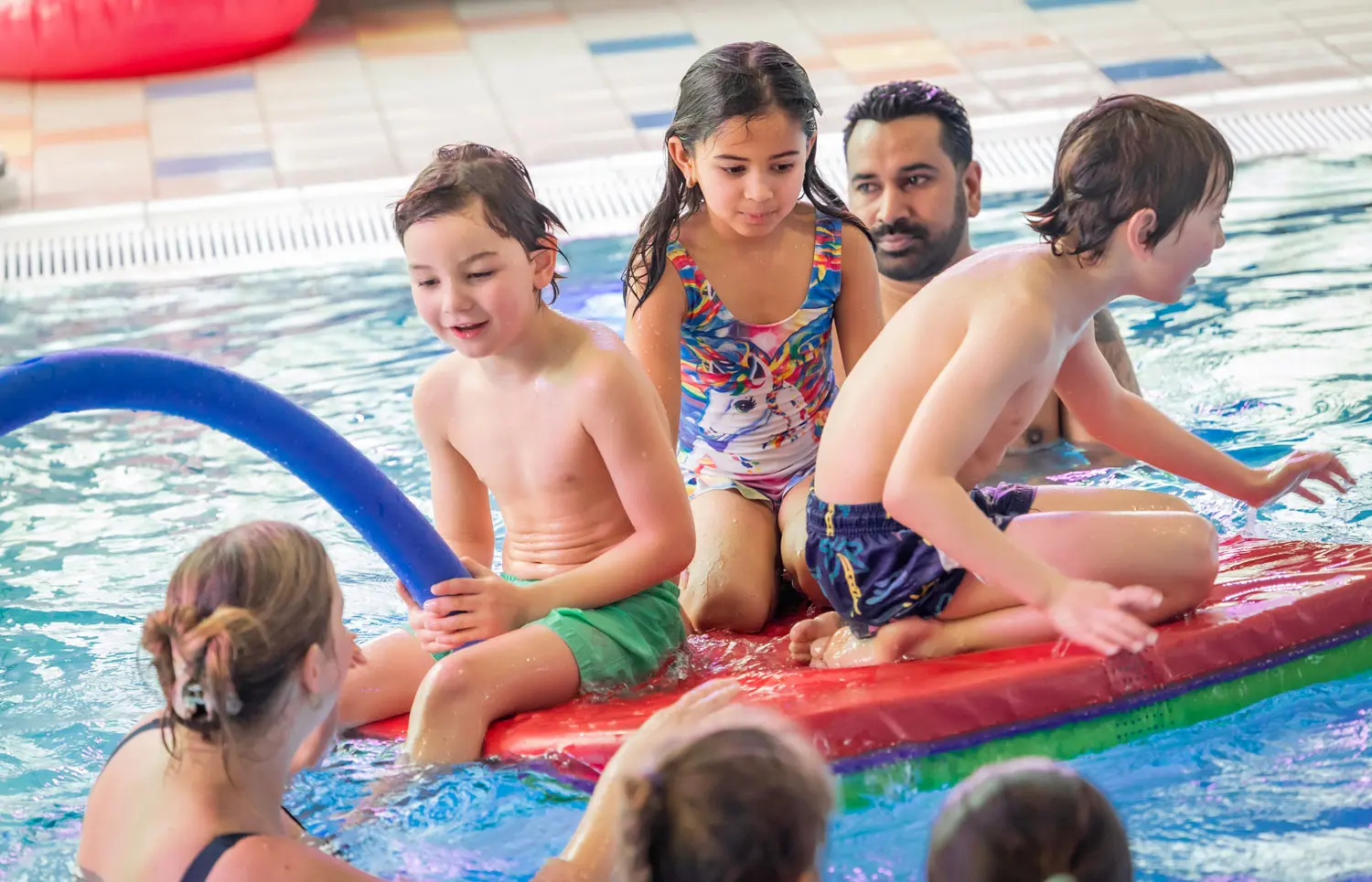 Kinderen op mat in het zwembad Aquacentrum malkander